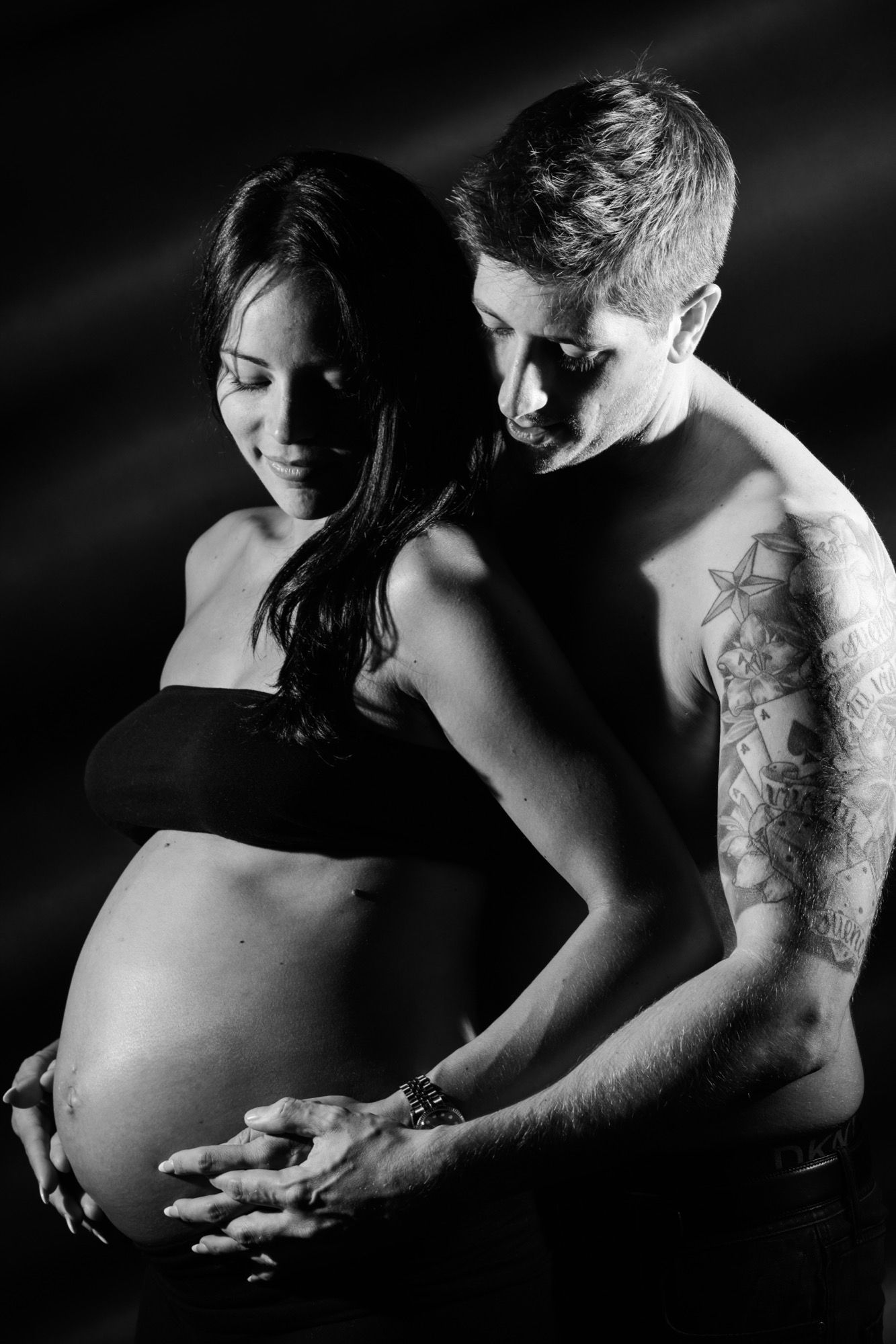Paar umarmt den Babybauch, Schwarz-Weiß-Aufnahme