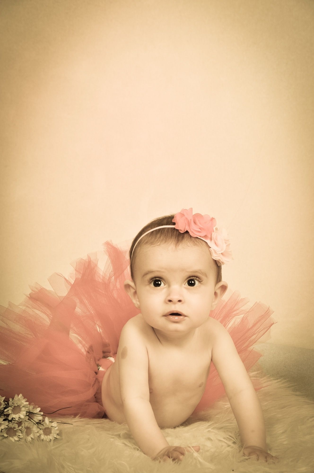 Neonata con gonna di tulle rosa e fiocco tra i capelli