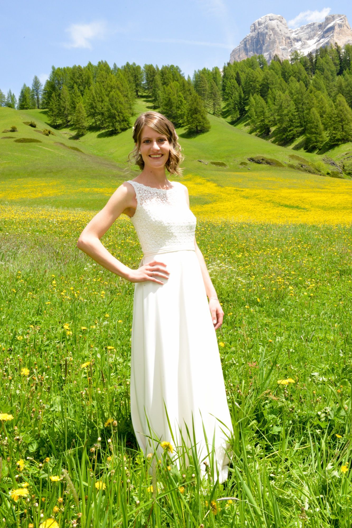 Sposa su un prato fiorito con le montagne sullo sfondo